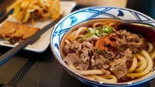 a blue and white bowl filled with noodles and meat